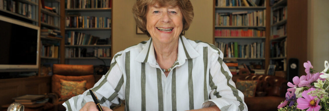 Pam Ayres posing with a book to advertise her show Doggedly Onward