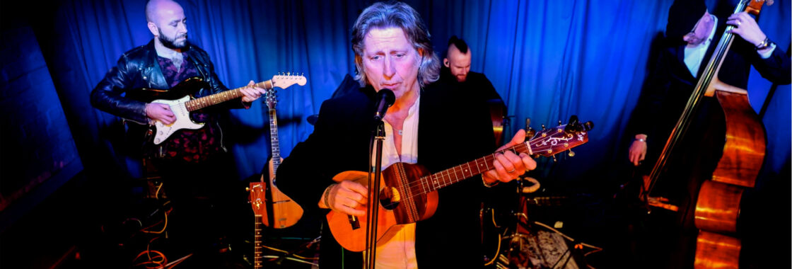 Steve Knightley singing to camera while playing guitar