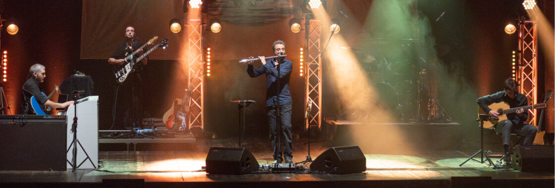 The Watch Plays Genesis playing on an orange and green lit stage.