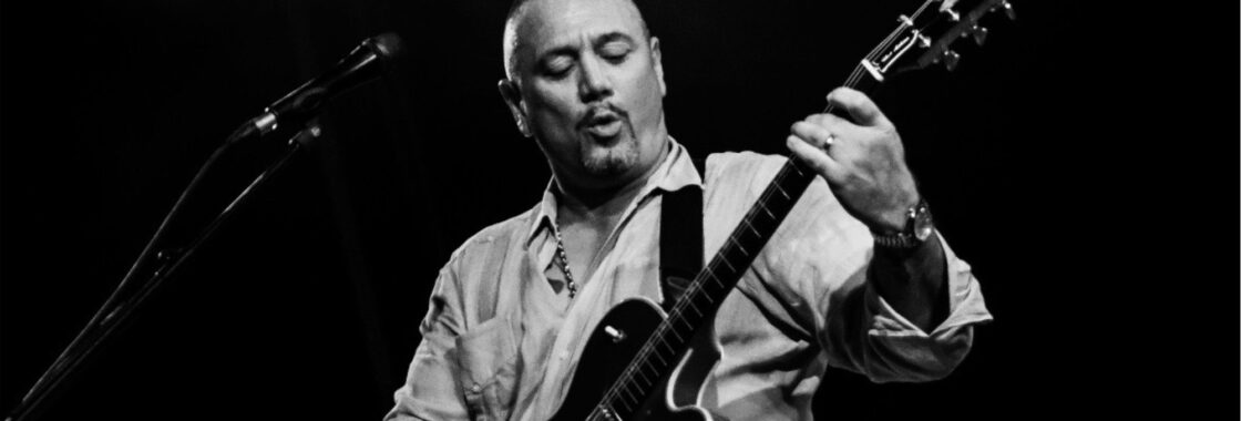 Huey Morgan - a white man wearing a white shirt - plays guitar